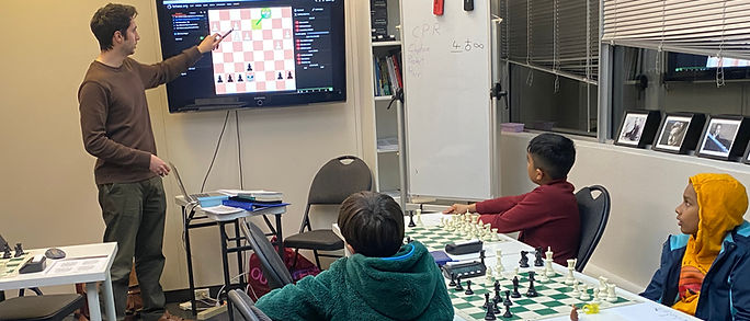 Chess lesson with kids listening to the coach
